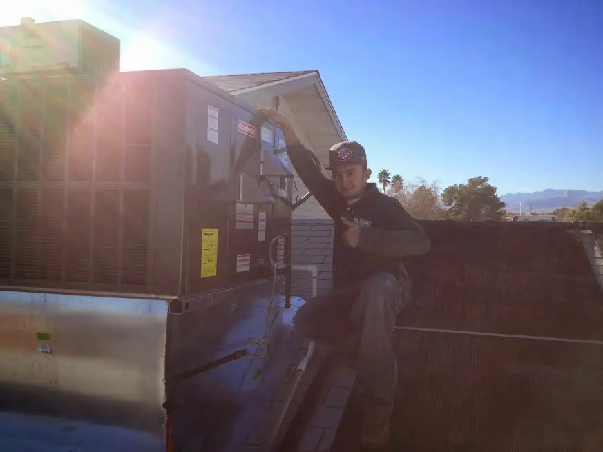 HVAC technician performing AC Tune-Up on a rooftop unit in Church Hill